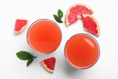 Photo of Tasty freshly made grapefruit juice and fruits on white background, top view
