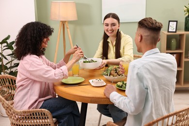 Photo of Friends having vegetarian meal at table in cafe
