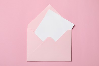 Photo of Letter envelope with card on pink background, top view