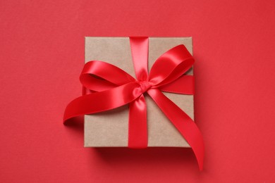 Photo of Beautiful gift box with bow on red background, top view