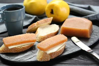 Photo of Tasty sandwiches with quince paste served on black wooden table, closeup