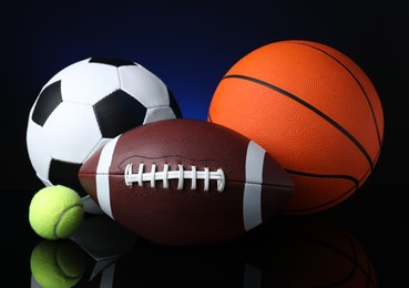 Photo of Set of different sport balls on black mirror surface