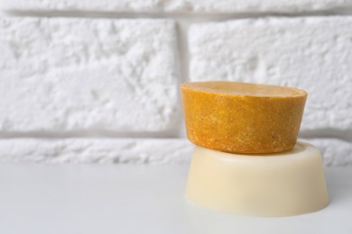 Photo of Orange solid shampoo bars on white table, closeup. Space for text