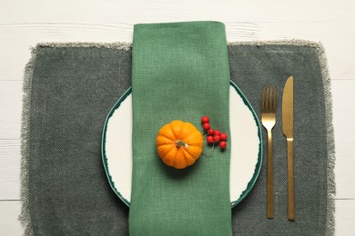 Photo of Autumn table setting, pumpkin and red berries, flat lay
