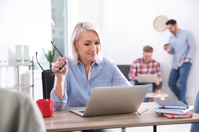 Photo of Businesswoman with colleagues working in office. Professional communication