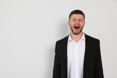 Photo of Aggressive young man shouting on white background, space for text