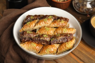 Delicious sweet baklava in bowl on wooden table