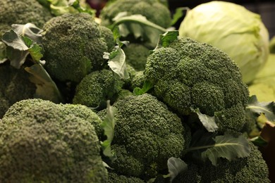 Fresh broccoli and cabbages on counter at market, closeup