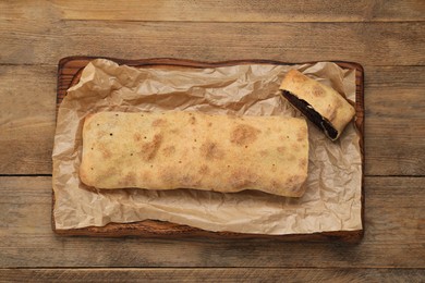 Delicious strudel with tasty filling on wooden table, top view