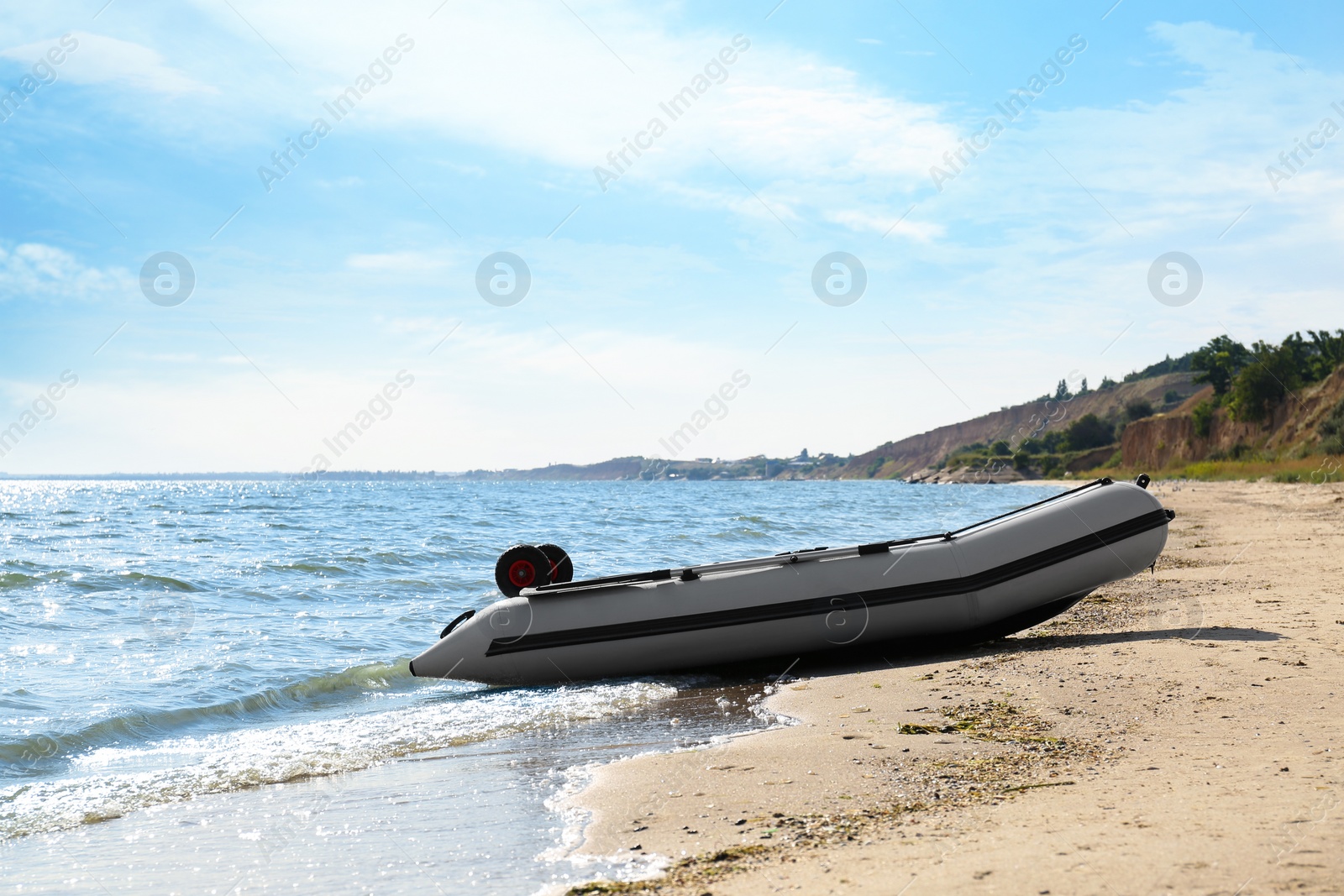 Photo of Inflatable rubber fishing boat on sandy beach near sea