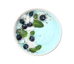 Photo of Bowl of spirulina smoothie with coconut, blueberries and chia seeds isolated on white, top view