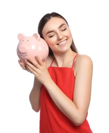 Happy young woman with piggy bank on white background