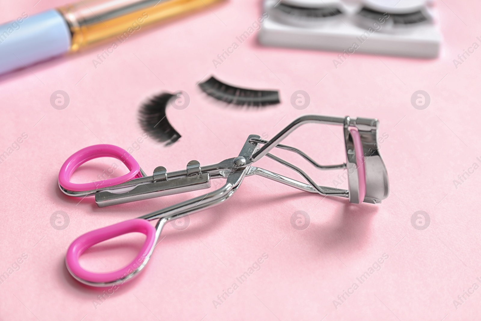 Photo of Eyelash curler on color background, closeup