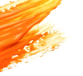 Photo of Abstract brushstroke of orange paint isolated on white