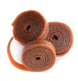 Delicious fruit leather rolls on white background, top view