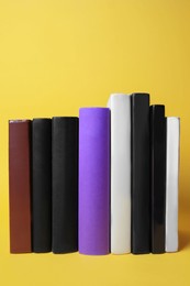 Collection of hardcover books on yellow background