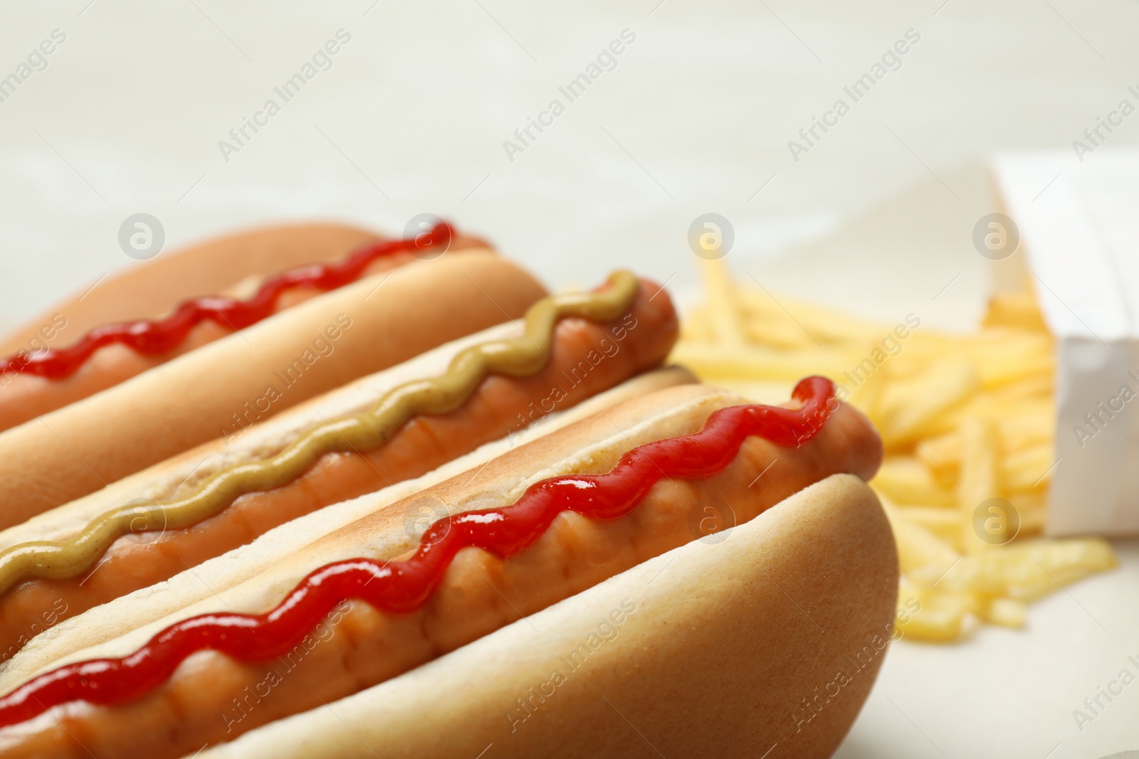 Photo of Tasty hot dogs with mustard and ketchup on table, closeup