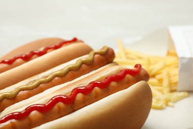 Tasty hot dogs with mustard and ketchup on table, closeup