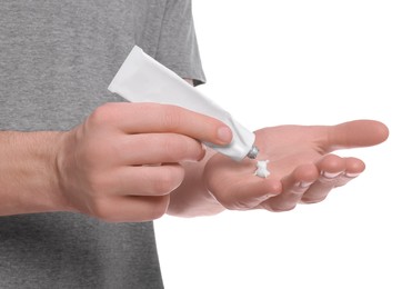 Photo of Man applying ointment from tube onto his hand on white background, closeup