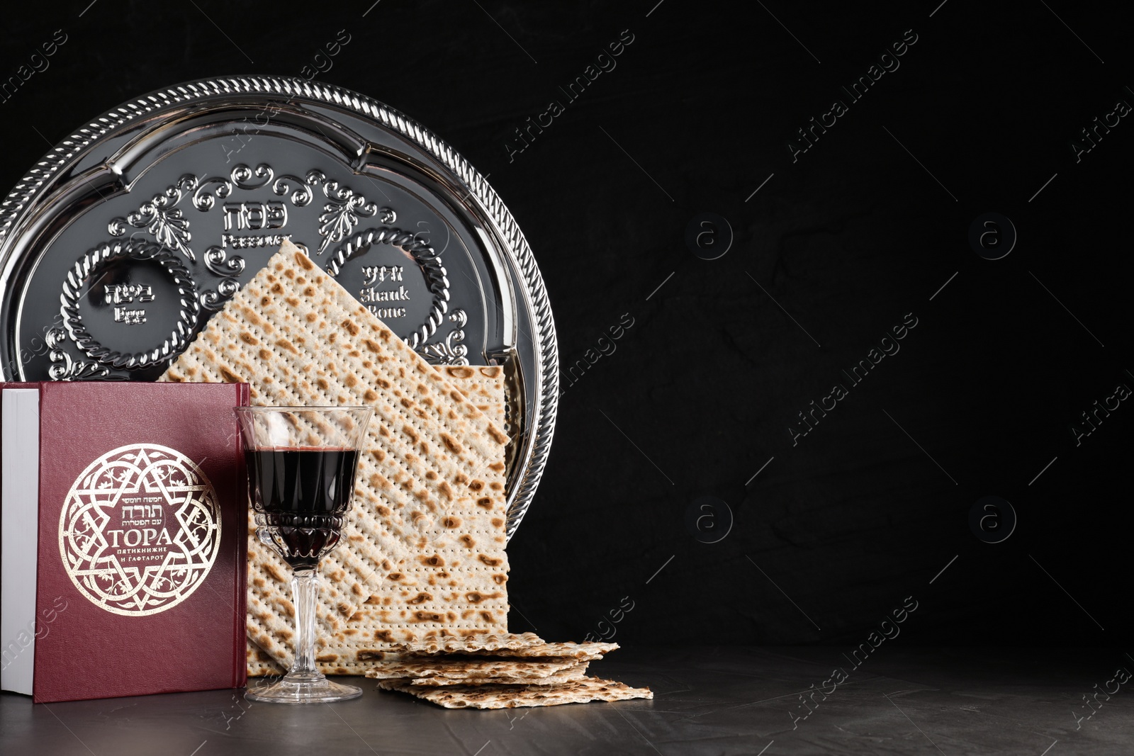 Photo of Symbolic Pesach (Passover Seder) items on black table, space for text