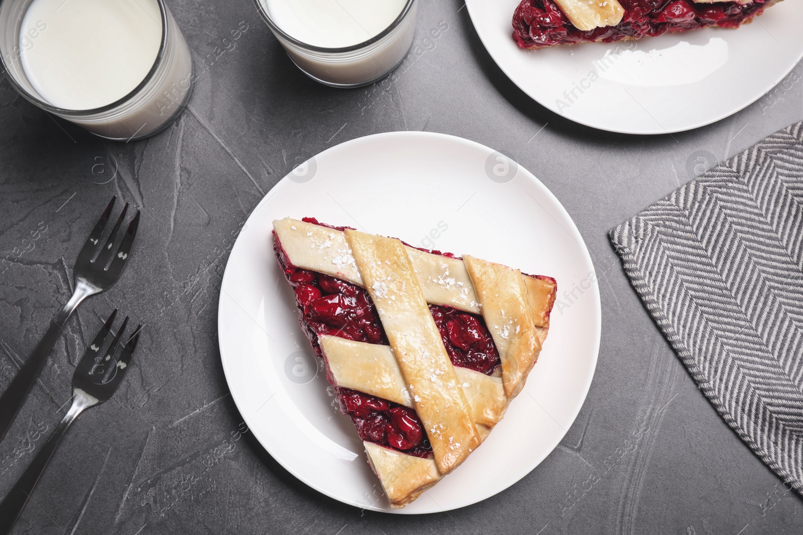 Photo of Slice of delicious fresh cherry pie served on grey table, flat lay