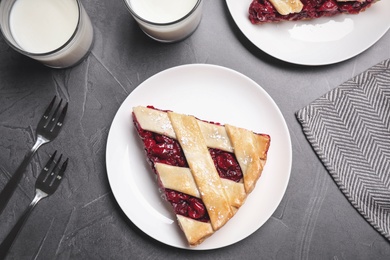Photo of Slice of delicious fresh cherry pie served on grey table, flat lay