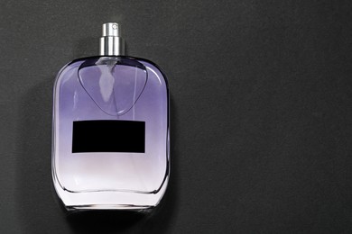 Luxury men`s perfume in bottle on black background, top view. Space for text