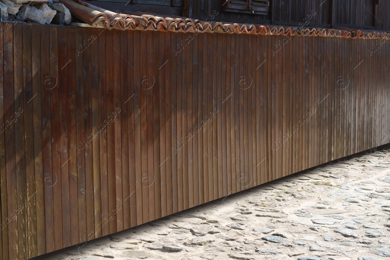 Photo of Shabby wooden fence outdoors on sunny day