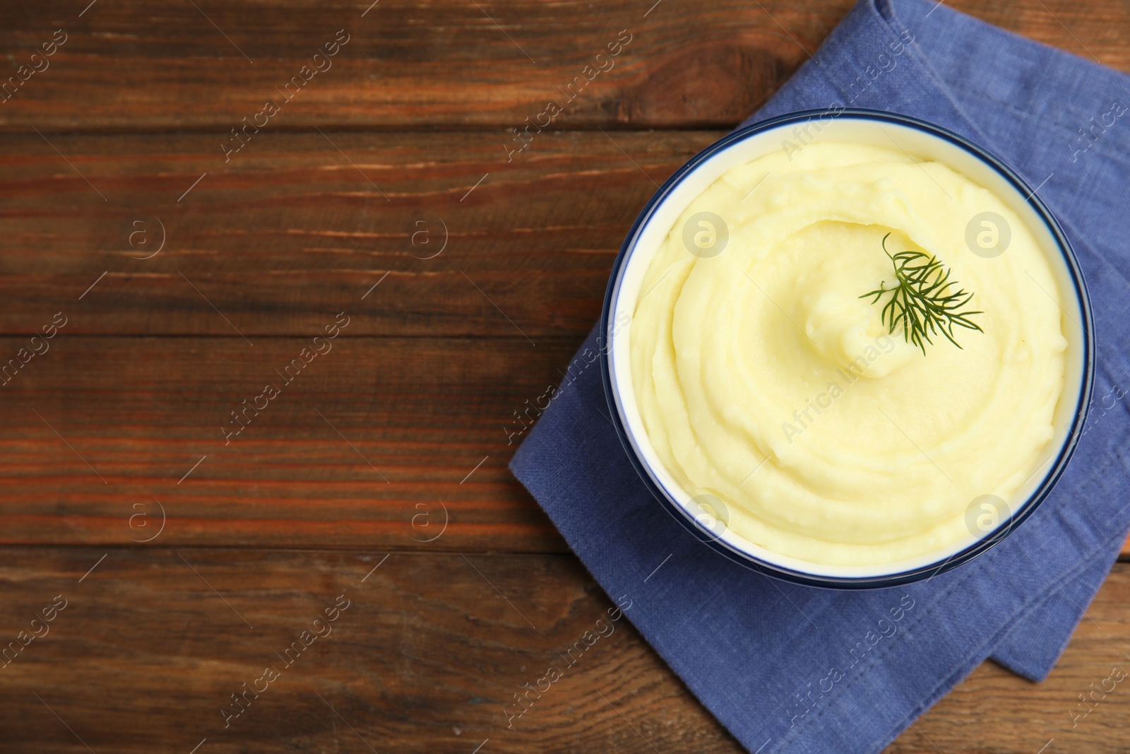 Photo of Freshly cooked homemade mashed potatoes on wooden table, top view. Space for text