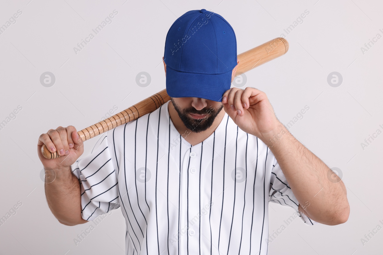 Photo of Man in stylish blue baseball cap holding bat on white background