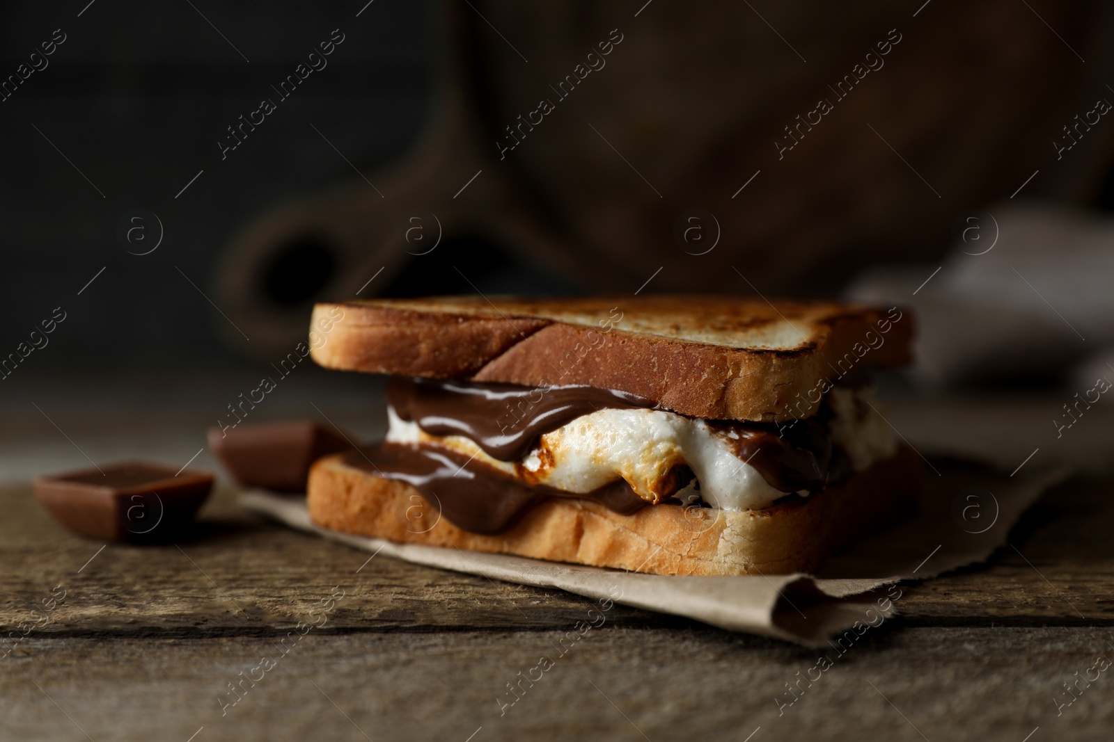 Photo of Delicious marshmallow sandwich with bread and chocolate on wooden table, closeup