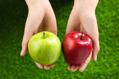 Woman holding fresh ripe red and green apples outdoors, closeup