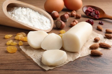 Photo of Marzipan and other ingredients for homemade Stollen on wooden table. Baking traditional German Christmas bread