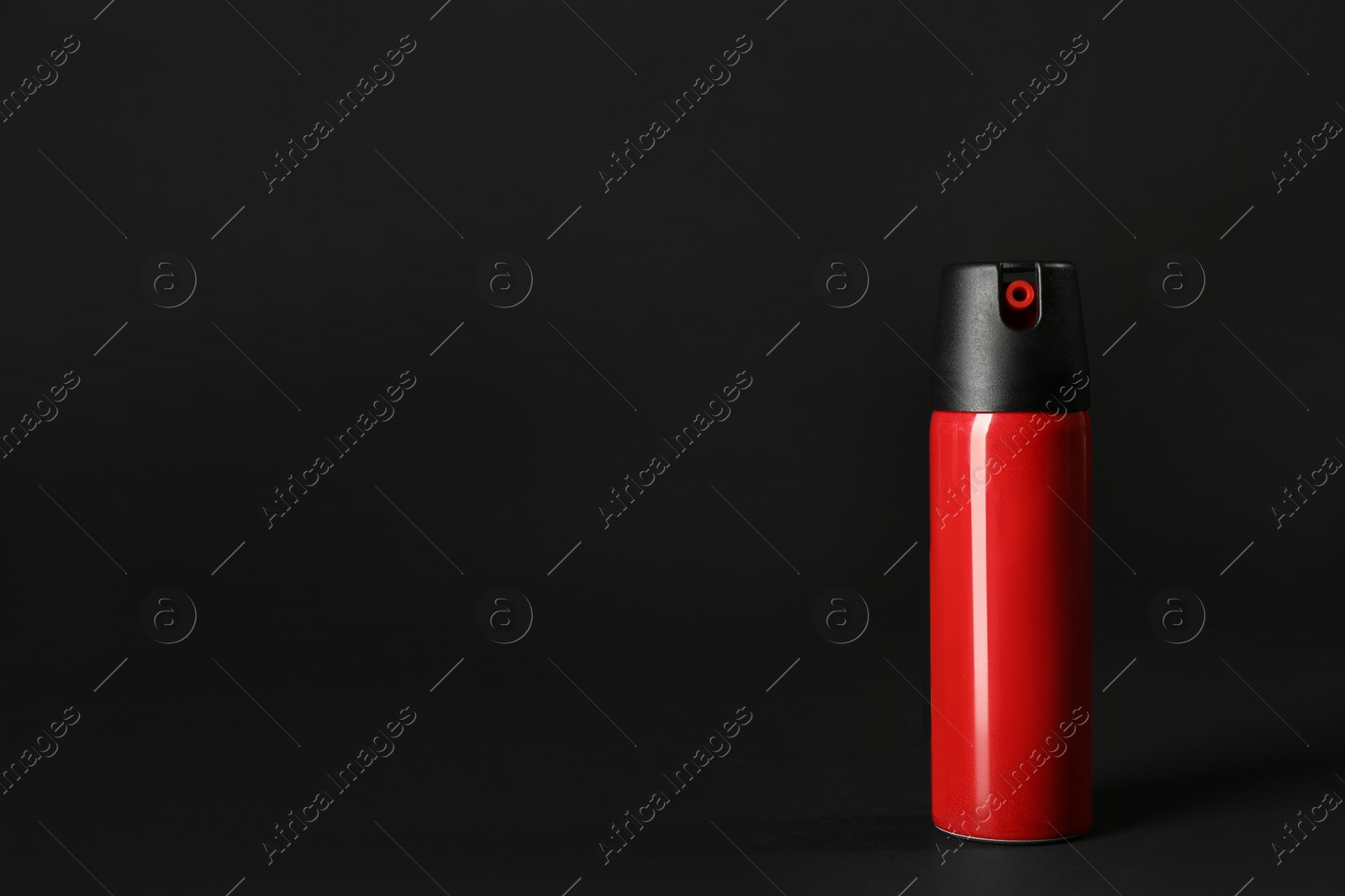 Photo of Bottle of gas pepper spray on black background. Space for text