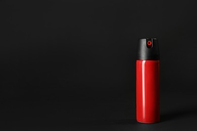 Bottle of gas pepper spray on black background. Space for text