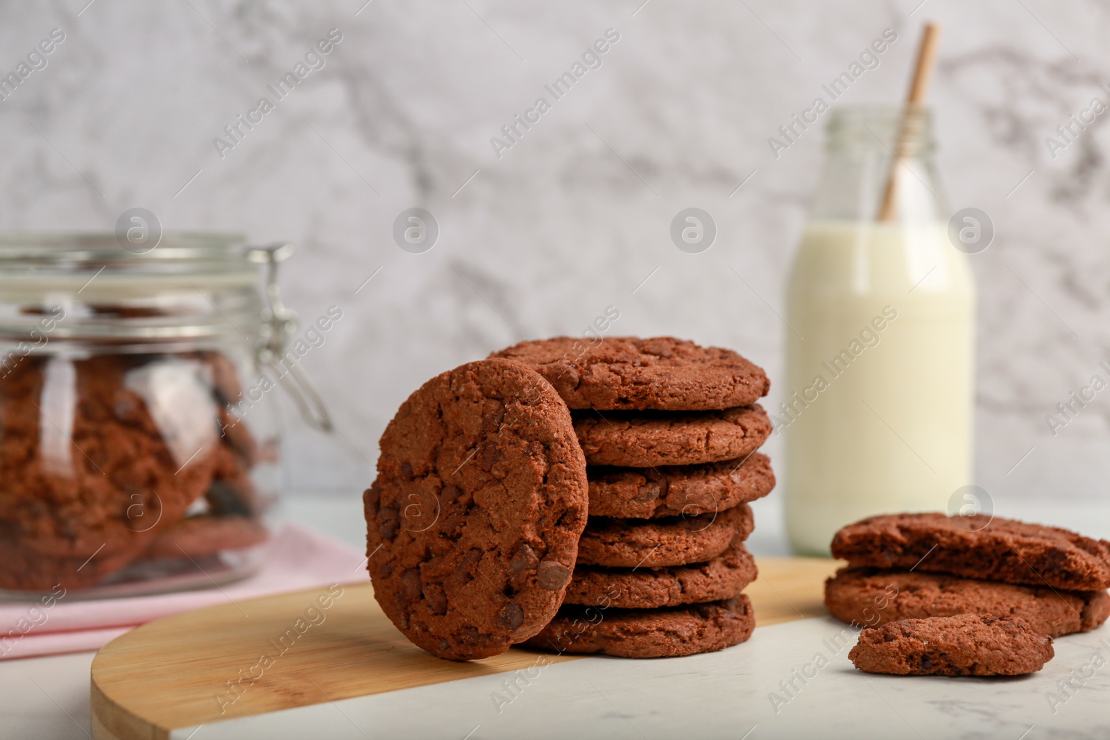 Photo of Board with tasty chocolate cookies on white table, closeup