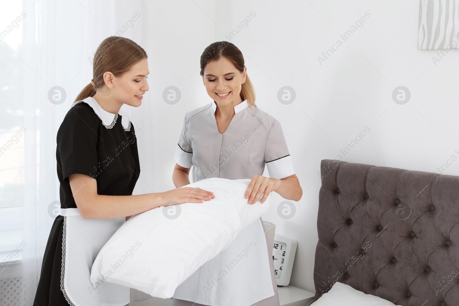 Photo of Professional chambermaids making bed in hotel room