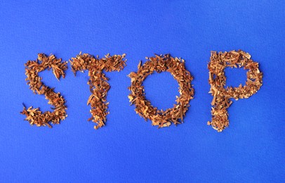 Photo of Word Stop made of dry tobacco on blue background, flat lay. Quitting smoking concept