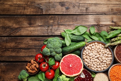 Photo of Fresh vegetables, fruits and seeds on wooden table, flat lay. Space for text