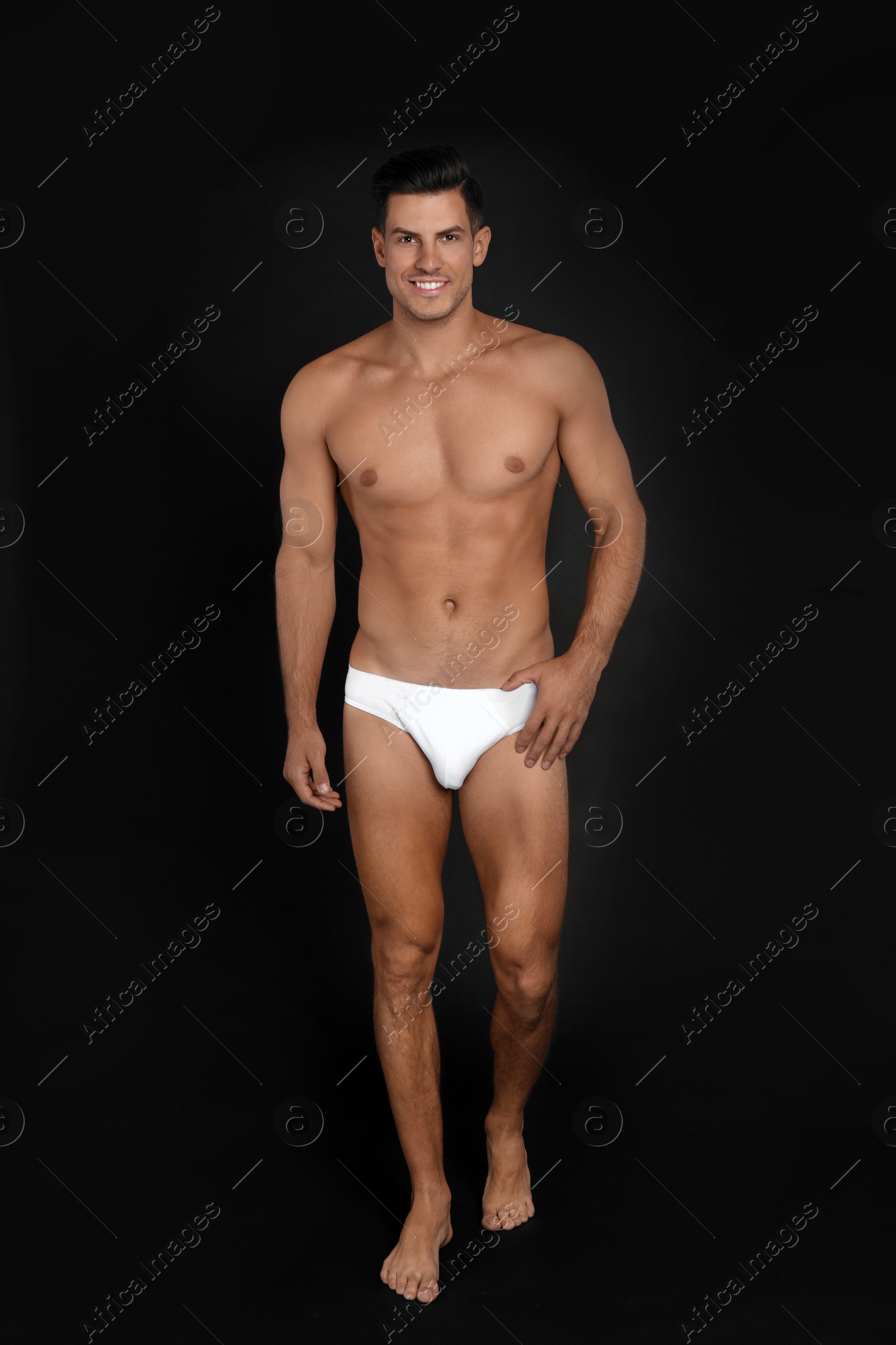 Photo of Handsome man in underwear on black background