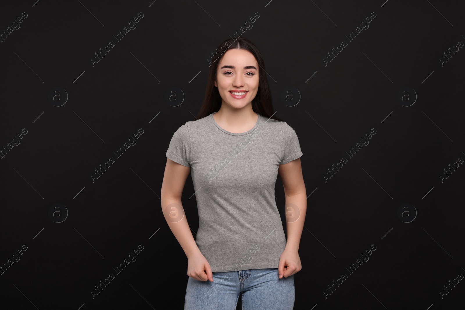 Photo of Woman wearing grey t-shirt on black background