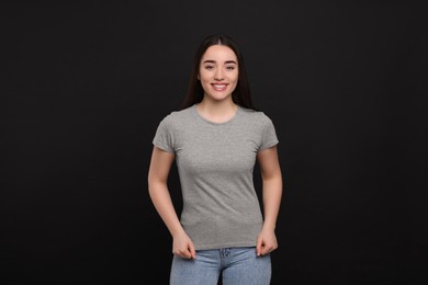 Photo of Woman wearing grey t-shirt on black background