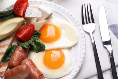 Delicious breakfast with fried eggs served on table, closeup