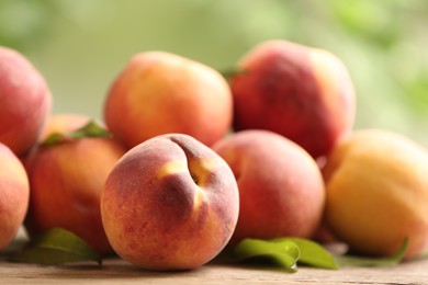 Photo of Fresh sweet peaches on wooden table outdoors, closeup