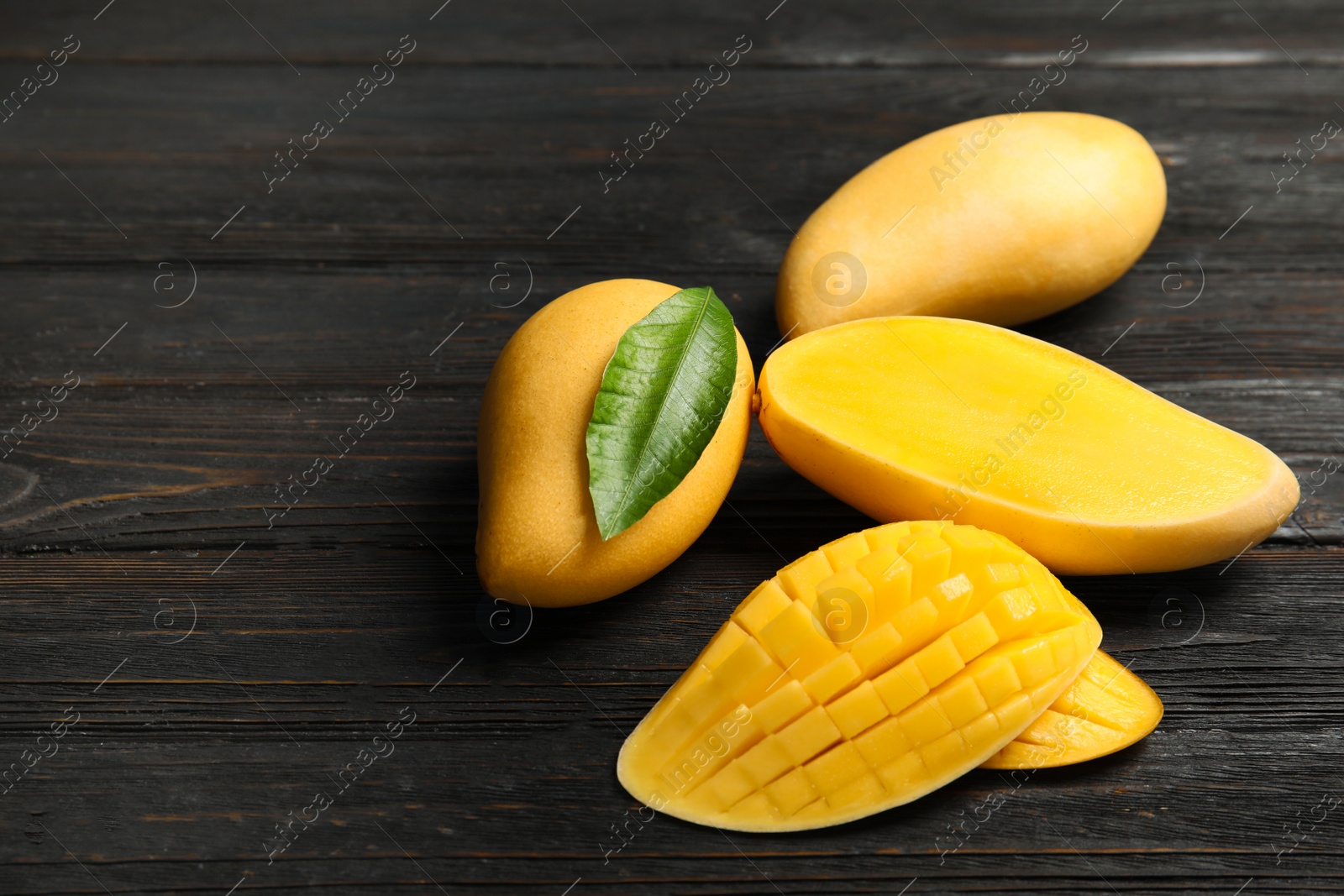 Photo of Ripe mango on wooden table. Space for text