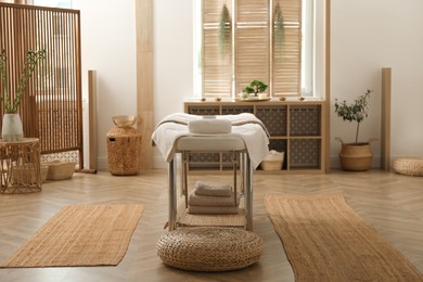 Stylish massage room interior with spa table in salon