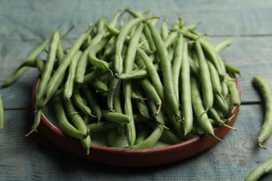Photo of Fresh green beans on blue wooden table, closeup