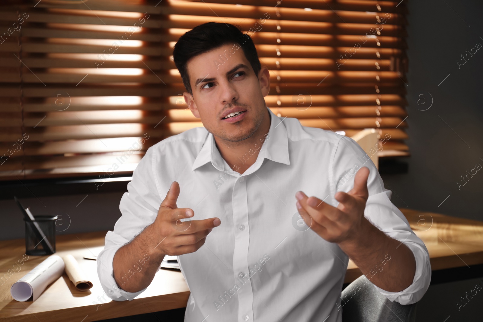 Photo of Man talking to his coworkers through video conference indoors, view from webcam