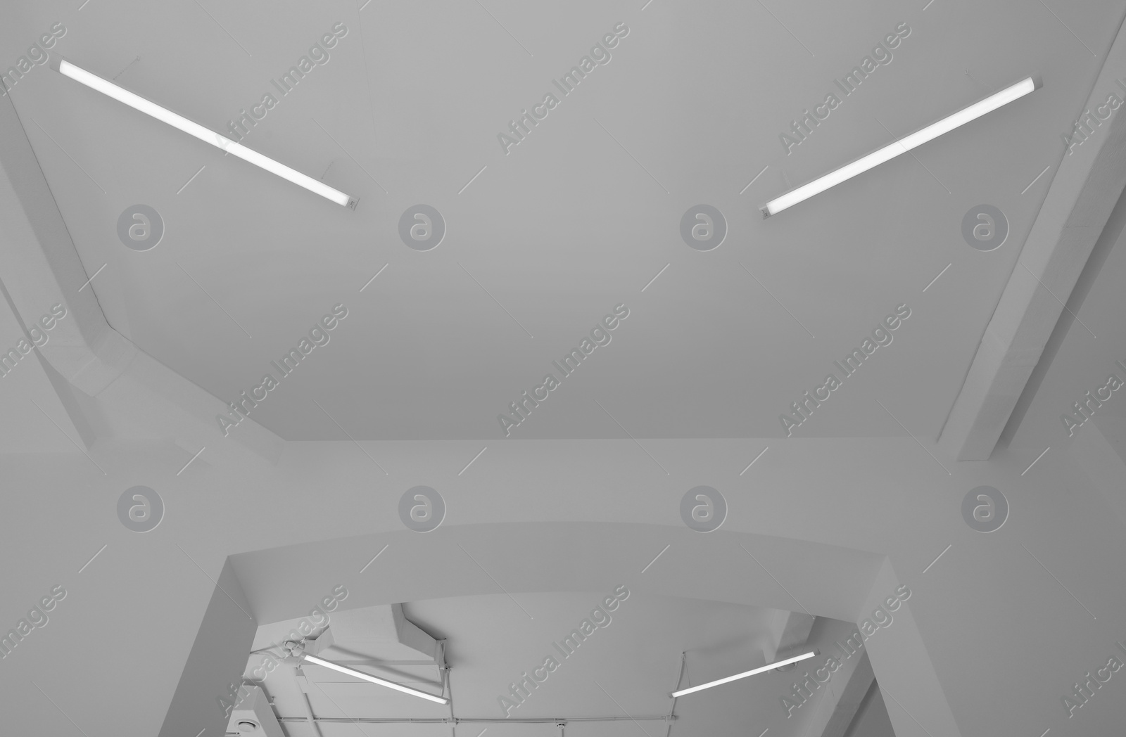 Photo of White ceiling with modern lighting in room, low angle view