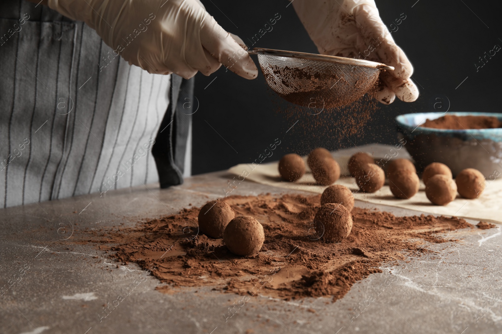 Photo of Woman preparing tasty chocolate truffles at table, closeup